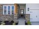 Elegant front door with stone accents and wood trim at 6323 Willow Branch Way, Plainfield, IN 46168