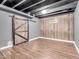 Finished basement area with a rustic sliding barn door and wood-paneled wall at 6620 Avalon Blvd, Avon, IN 46123