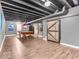Spacious basement area with a pool table, barn door, and modern lighting fixtures at 6620 Avalon Blvd, Avon, IN 46123