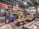Basement wet bar area featuring custom shelving, bar fridge, and leather sofa seating at 6620 Avalon Blvd, Avon, IN 46123