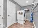 The laundry room has a washer, dryer, utility sink, shelving, and updated vinyl plank flooring at 6620 Avalon Blvd, Avon, IN 46123