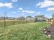 A large, grassy backyard with a black fence and patio furniture on a sunny day at 6915 Diamondleaf Way, Brownsburg, IN 46112