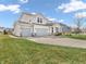 Two-story home with gray siding, white trim, a well-manicured lawn, and a three car garage at 6915 Diamondleaf Way, Brownsburg, IN 46112