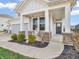 Covered front porch with stone accents, a white rocking chair, and manicured landscaping at 6915 Diamondleaf Way, Brownsburg, IN 46112