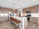 Spacious kitchen with stainless steel appliances, quartz counters, and seating at the island at 6915 Diamondleaf Way, Brownsburg, IN 46112