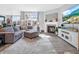 Cozy living room with hardwood floors, a gray sectional, a fireplace, and a large TV at 6915 Diamondleaf Way, Brownsburg, IN 46112