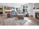 Open-concept living room with hardwood floors, a gray sectional, and a fireplace at 6915 Diamondleaf Way, Brownsburg, IN 46112