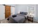 Bedroom with barn door to bathroom, hardwood floors, and natural light at 721 E Morris St, Indianapolis, IN 46203