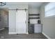 A stylish basement bar area with a barn door, a beverage cooler, countertop space, and open shelving for storage at 7228 Broadacre Ct, Carmel, IN 46033