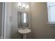 Bathroom with pedestal sink, decorative mirror and lighting at 7228 Broadacre Ct, Carmel, IN 46033