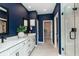 Bathroom suite with white cabinets, double vanity, blue walls, and tiled floors at 7572 Bluegill Dr, Noblesville, IN 46062