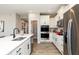 Modern kitchen with stainless steel appliances, white cabinets, an island, and wood-look floors at 7572 Bluegill Dr, Noblesville, IN 46062
