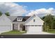 Charming brick and board and batten home featuring a two-car garage, and manicured landscaping at 7596 Bluegill Dr, Noblesville, IN 46062