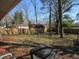 Spacious backyard with mature trees, a wooden fence, a patio, and room for outdoor activities at 7625 Partridge Rd, Indianapolis, IN 46227