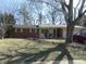 Charming brick ranch-style home with a covered front porch and attached garage, and mature landscaping at 7625 Partridge Rd, Indianapolis, IN 46227
