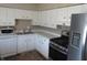 Well-lit kitchen featuring white cabinets, white countertops, stainless steel appliances, and decorative knobs at 7625 Partridge Rd, Indianapolis, IN 46227