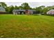 Large backyard with lush green grass, perfect for and pets, including a trampoline and playhouse at 8172 Shottery Ter, Indianapolis, IN 46268