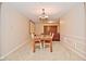 Minimalist dining room with carpet, including a vintage dining table with seating and a glimpse of living area at 8172 Shottery Ter, Indianapolis, IN 46268