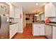 Open kitchen design with dark countertops and wood flooring, flowing into living space at 8172 Shottery Ter, Indianapolis, IN 46268
