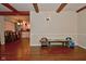 Open-concept living room with exposed beams and wood-look flooring, connected to dining area with kitchen view at 8172 Shottery Ter, Indianapolis, IN 46268