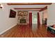 Spacious living room with wood-look floors, a brick fireplace, and natural light from the sliding glass door at 8172 Shottery Ter, Indianapolis, IN 46268