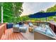 Spacious outdoor deck featuring comfortable seating area with umbrella and stunning lake views surrounded by lush greenery at 8205 Bass Dr, Nineveh, IN 46164
