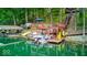 Multi-level boat dock with upper patio seating, lifts for boats and jet skis on a tranquil waterfront at 8205 Bass Dr, Nineveh, IN 46164