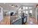 Bright, open kitchen and living room featuring hardwood floors, cathedral ceilings, and a kitchen island with cooktop at 8205 Bass Dr, Nineveh, IN 46164
