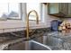 Close-up of a kitchen sink and countertop, featuring a modern faucet and granite countertops at 8205 Bass Dr, Nineveh, IN 46164