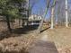 View of the home's exterior with a deck, set amongst trees, and a path leading to the water at 8460 S Green Dr, Nineveh, IN 46164