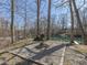 Outdoor firepit area with gravel and brick surround is nestled amongst mature trees and landscaping at 8460 S Green Dr, Nineveh, IN 46164