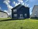 Rear exterior of home featuring blue siding, a sliding glass door, and a spacious backyard at 8626 Jeff Cir, Brownsburg, IN 46112