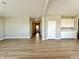 Bright living room featuring light-colored walls and hardwood flooring with an entry hallway in the background at 8626 Jeff Cir, Brownsburg, IN 46112