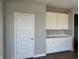 Mudroom area featuring overhead cabinets and lower drawers, with a door leading outside at 8626 Jeff Cir, Brownsburg, IN 46112