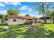 Spacious backyard featuring a patio, lush lawn, and mature trees under a blue sky at 8715 Legion Ln, Indianapolis, IN 46231