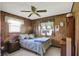 Bedroom featuring wood panel walls, carpet flooring, and window with curtains at 8715 Legion Ln, Indianapolis, IN 46231