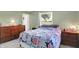 Bedroom featuring a window view, neutral walls, and a colorful bed spread at 8715 Legion Ln, Indianapolis, IN 46231