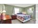 Bedroom with green walls, two windows, and a colorful quilt on the bed at 8715 Legion Ln, Indianapolis, IN 46231