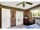 Bedroom featuring wood panel walls, carpet flooring, and window with curtains at 8715 Legion Ln, Indianapolis, IN 46231