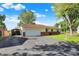 Ranch-style home with large driveway, covered parking, attached garage, and well-maintained landscaping at 8715 Legion Ln, Indianapolis, IN 46231
