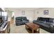 Comfortable living room with carpet, leather sofas, and view into the kitchen at 8715 Legion Ln, Indianapolis, IN 46231