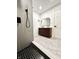 Modern bathroom with black and white tiled shower, floating wood vanity and geometric tile floors at 8795 Carrollton Ave, Indianapolis, IN 46240