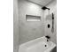Bright bathroom showcasing a tub-shower combo with white hexagon tile and black fixtures at 8795 Carrollton Ave, Indianapolis, IN 46240