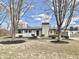 Charming single-story home with a stone chimney and well-maintained landscaping, offering great curb appeal at 8795 Carrollton Ave, Indianapolis, IN 46240
