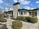 Charming single-story home with a stone chimney and black accents in a well-maintained landscape at 8795 Carrollton Ave, Indianapolis, IN 46240