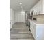 Spacious kitchen with modern stainless steel appliances, white cabinets, and stylish gray flooring throughout at 8795 Carrollton Ave, Indianapolis, IN 46240