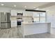 Bright and modern kitchen featuring stainless steel appliances, sleek white cabinetry, and a large island with a sink at 8795 Carrollton Ave, Indianapolis, IN 46240