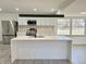 Bright, renovated kitchen with stainless steel appliances, modern white cabinets, and a spacious island with a sink at 8795 Carrollton Ave, Indianapolis, IN 46240