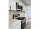 Close-up of a modern kitchen with stainless steel appliances, white countertops, and a stylish herringbone backsplash at 8795 Carrollton Ave, Indianapolis, IN 46240