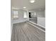 Sunlit living area features gray-toned flooring and open access to kitchen at 8795 Carrollton Ave, Indianapolis, IN 46240